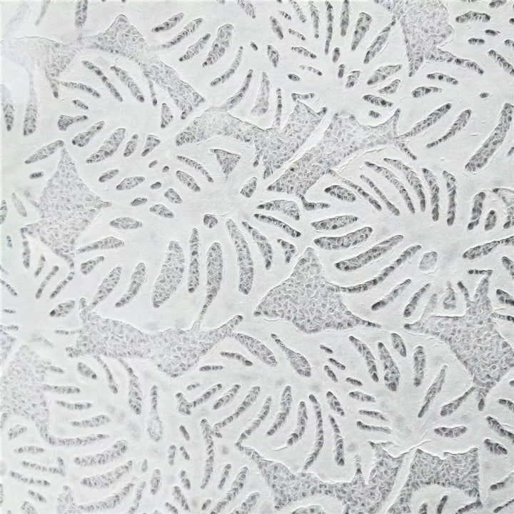 Artistic photograph of lace mulberry paper crafted by Kozo Studio, highlighting a Monstera leaf motif and delicate texture suitable for crafts, windows, or lighting.