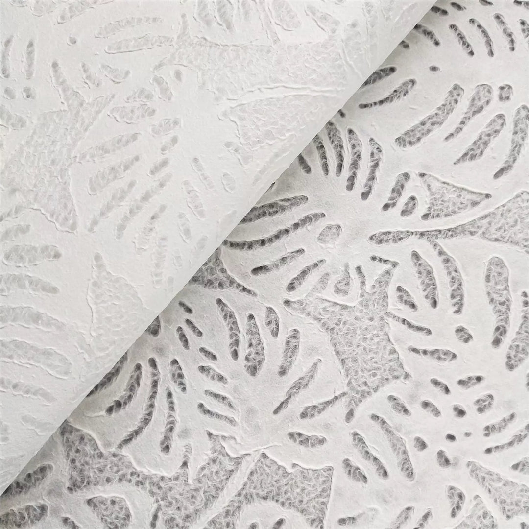Kozo Studio's white handmade paper with Monstera lace pattern, created from mulberry fibers, showcasing its versatility for art and interior design applications.