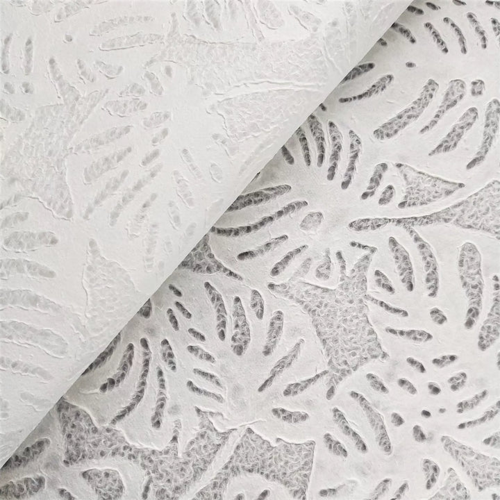 Kozo Studio's white handmade paper with Monstera lace pattern, created from mulberry fibers, showcasing its versatility for art and interior design applications.