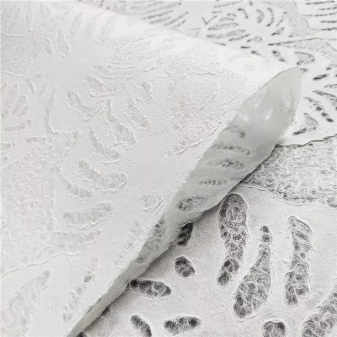 Translucent handmade mulberry paper by Kozo Studio, featuring an intricate Monstera leaf lace design, ideal for art installations, lampshades, and decorative use.