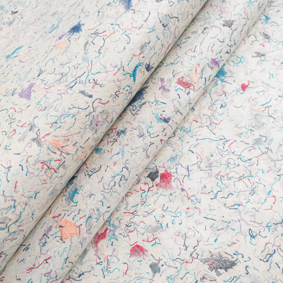 Artistic handmade mulberry paper from Kozo Studio with visible cotton fiber details, perfect for DIY crafts despite minor folding challenges.