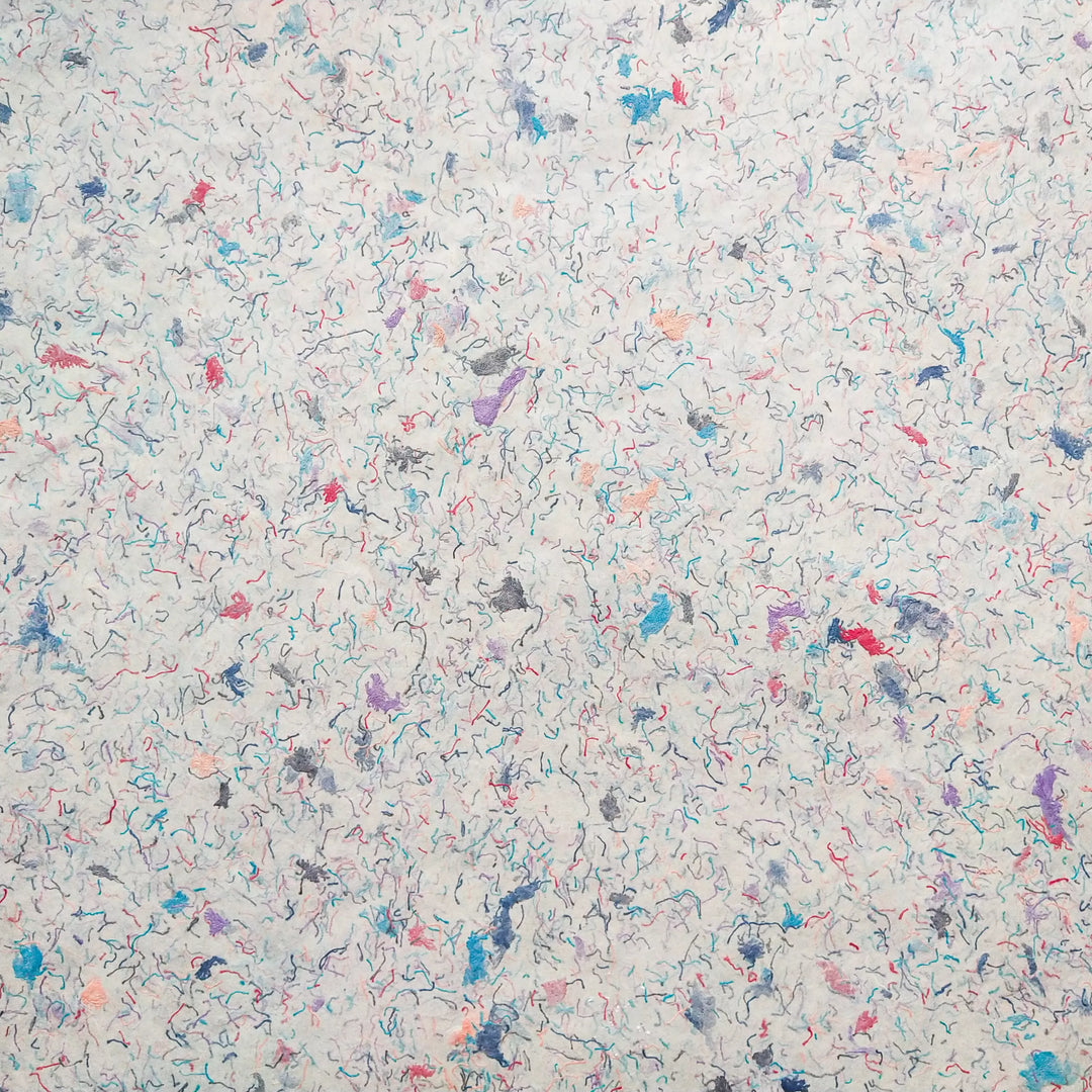 Medium weight mulberry paper by Kozo Studio featuring colorful cotton pieces, showcasing the texture and uniqueness of traditional handmade paper.