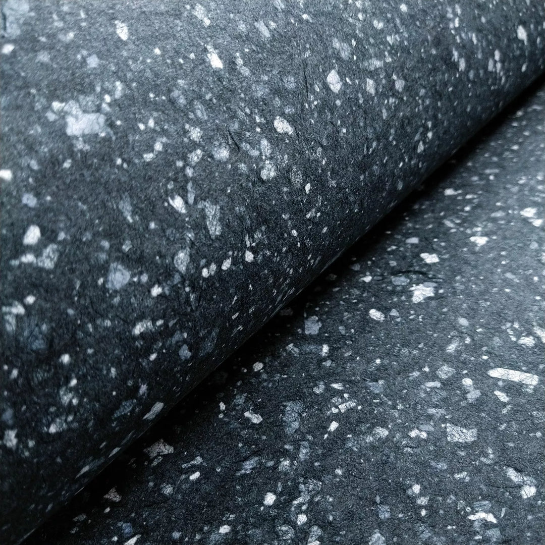 Artistic mulberry paper by Kozo Studio, showcasing a granite-like pattern created by scattering white bond paper on dark handmade kozo pulp.