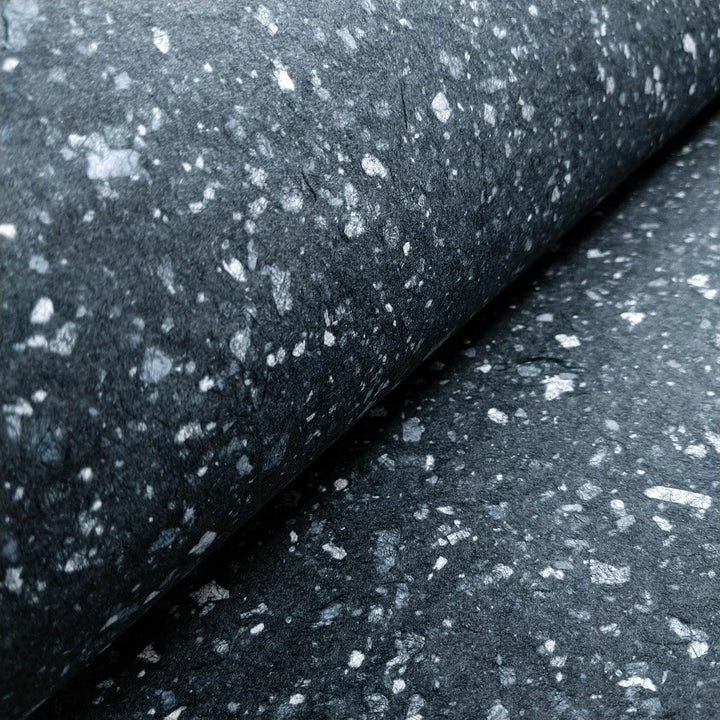 Artistic mulberry paper by Kozo Studio, showcasing a granite-like pattern created by scattering white bond paper on dark handmade kozo pulp.