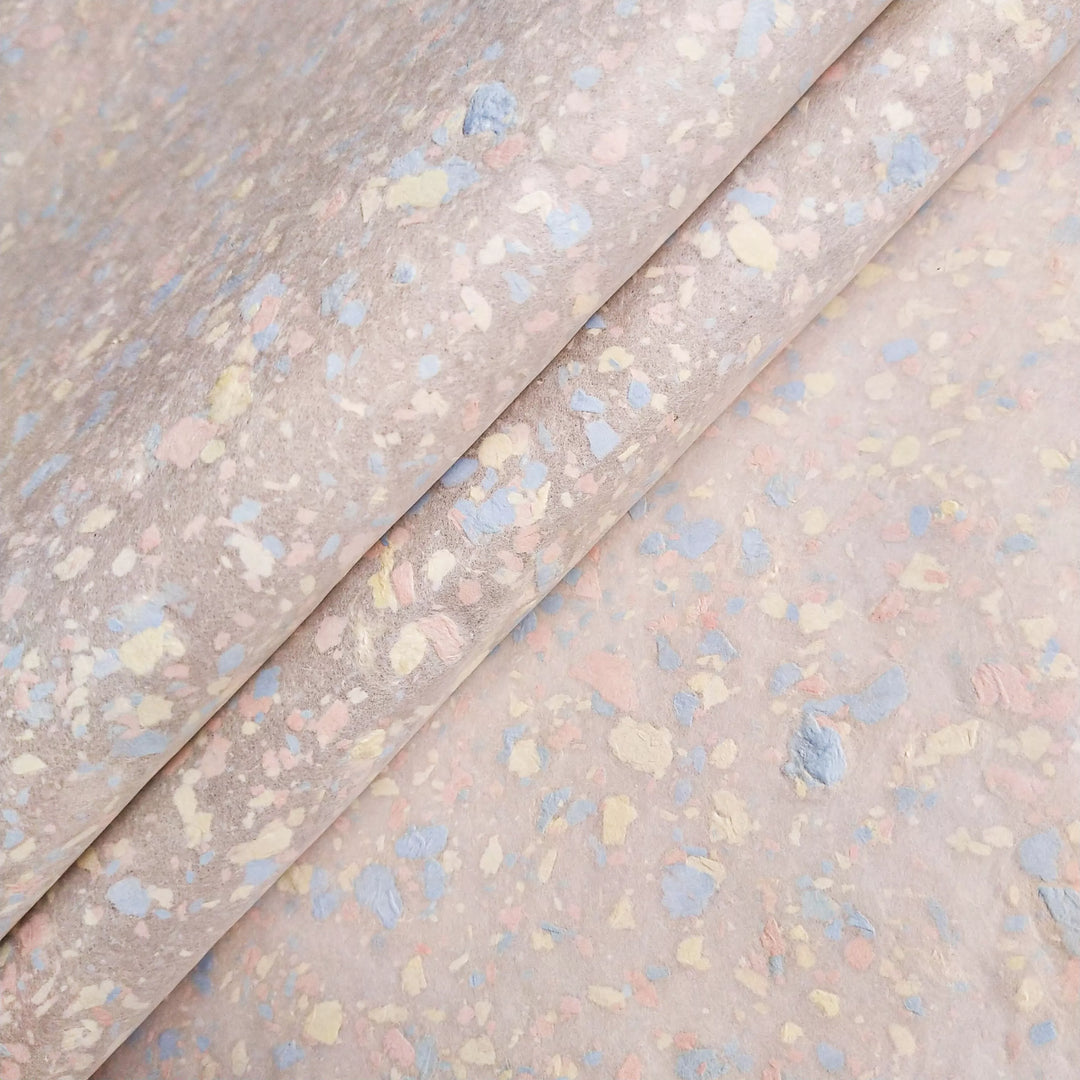 Pastel-colored fragments gently scattered over kozo pulp to form a medium-thick handmade mulberry paper sheet at Kozo Studio.