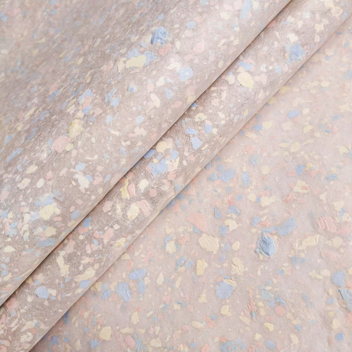 Pastel-colored fragments gently scattered over kozo pulp to form a medium-thick handmade mulberry paper sheet at Kozo Studio.