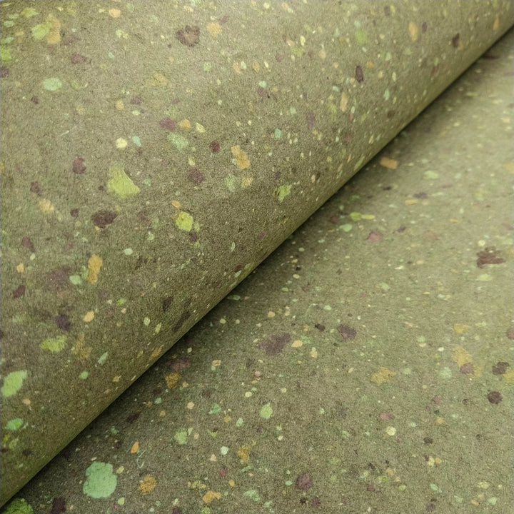 Delicate handmade paper featuring subtle speckles of bond paper on a mossy green kozo pulp background, crafted at Kozo Studio.