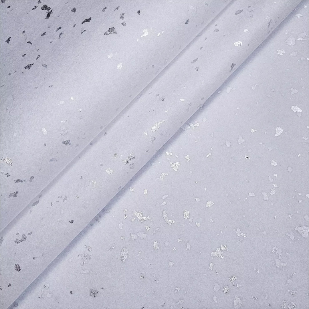 Elegant and delicate handmade mulberry paper featuring silver flakes, photographed in Kozo Studio to highlight its refined texture for artistic projects.