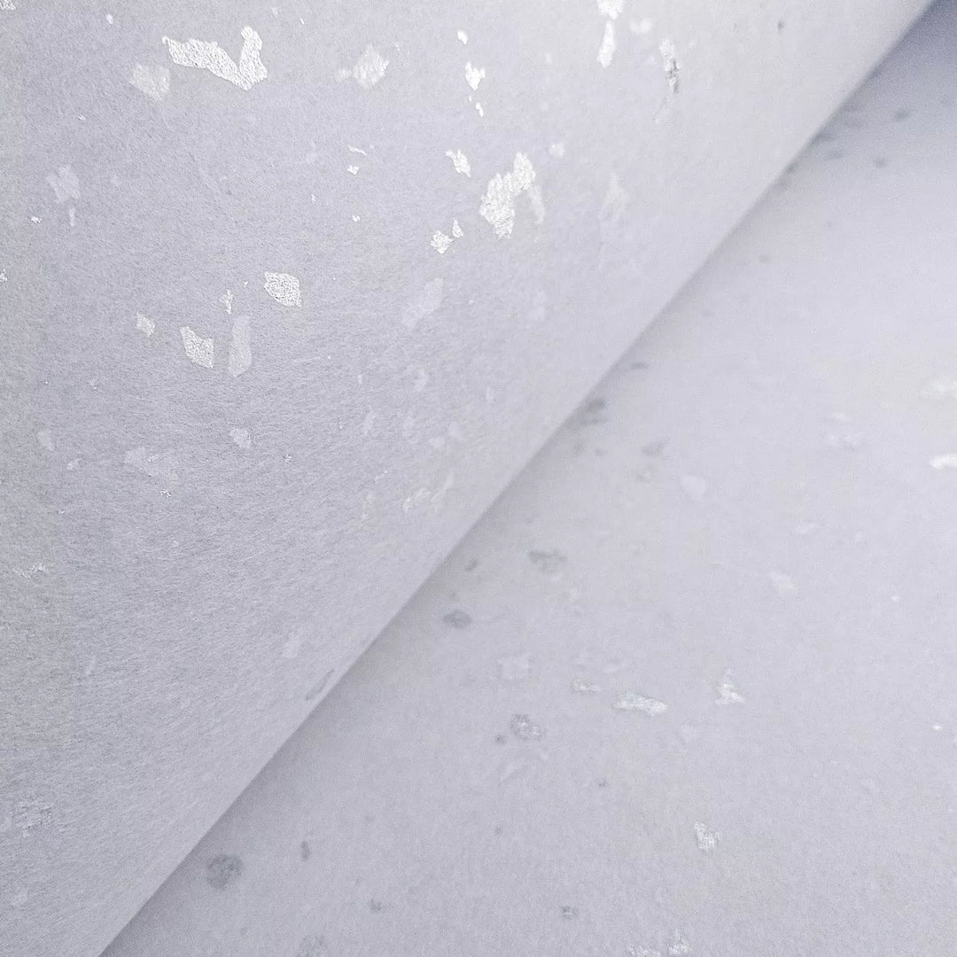 Close-up of sparkling silver elements on bright white handmade kozo paper from Kozo Studio, designed for standout creative work.