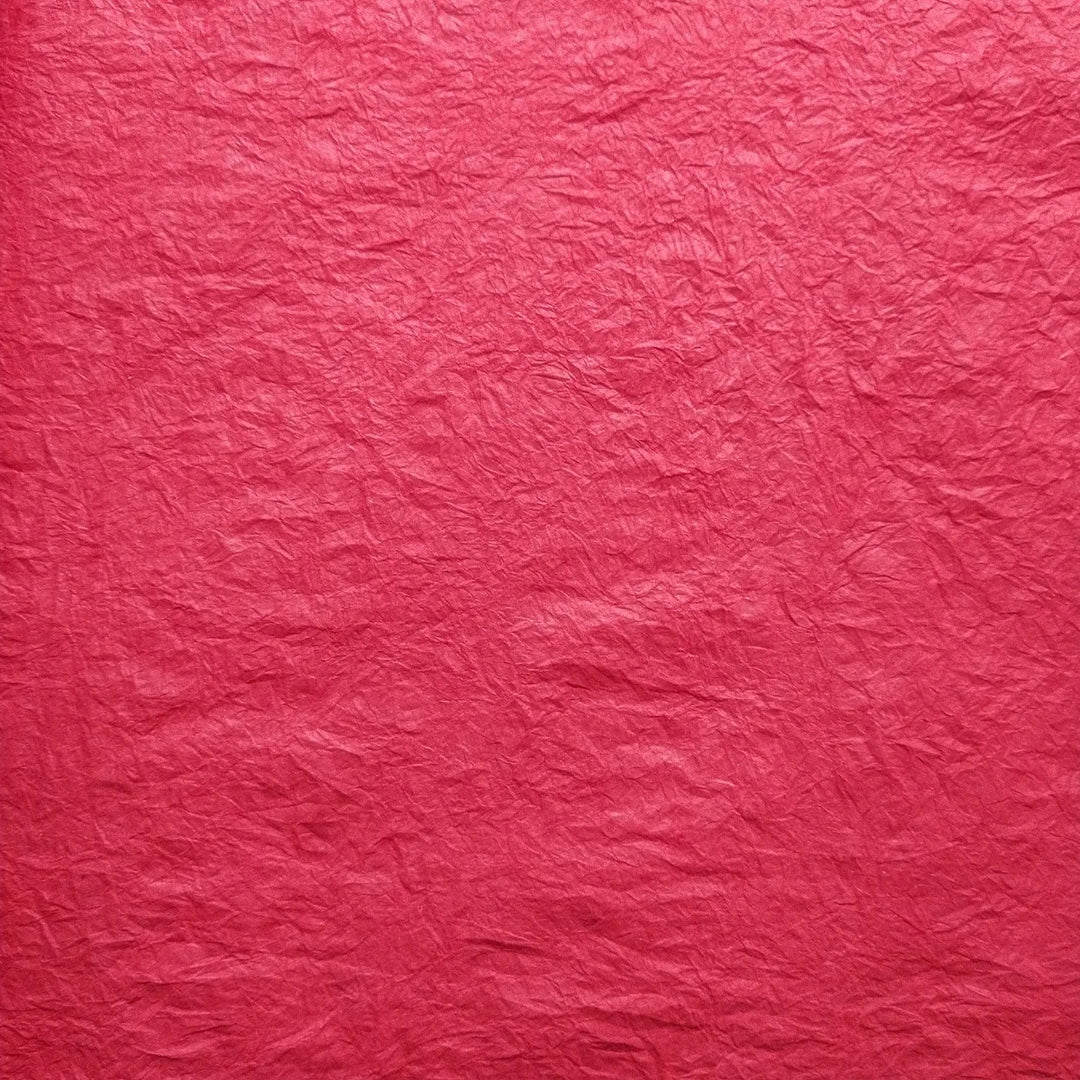 Handmade Momigami paper in vibrant red, made from mulberry fiber at Kozo Studio, showcasing its unique kneaded texture perfect for lampshades and decor.
