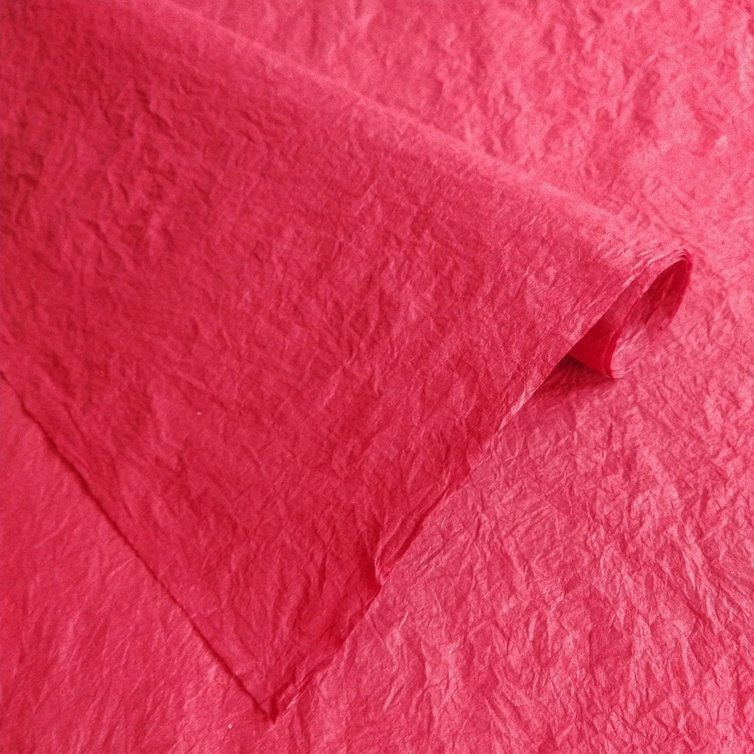 Artisan Momigami paper in red from Kozo Studio, a flexible mulberry paper option with a soft, crumpled texture ideal for wrapping, bags, and crafts.