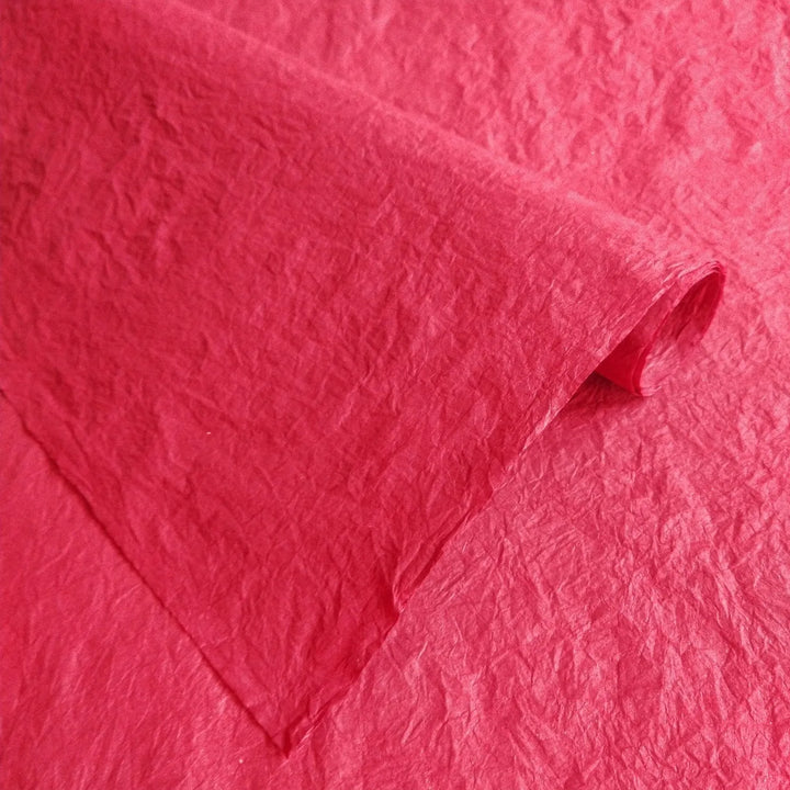 Artisan Momigami paper in red from Kozo Studio, a flexible mulberry paper option with a soft, crumpled texture ideal for wrapping, bags, and crafts.
