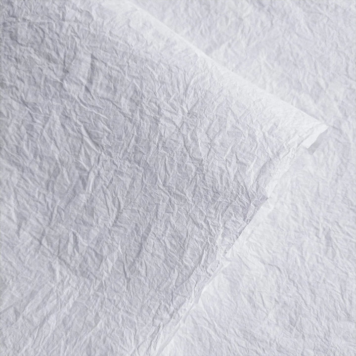 Textured white Momigami mulberry paper from Kozo Studio, showcasing its crumpled handmade surface ideal for bookbinding and crafts.