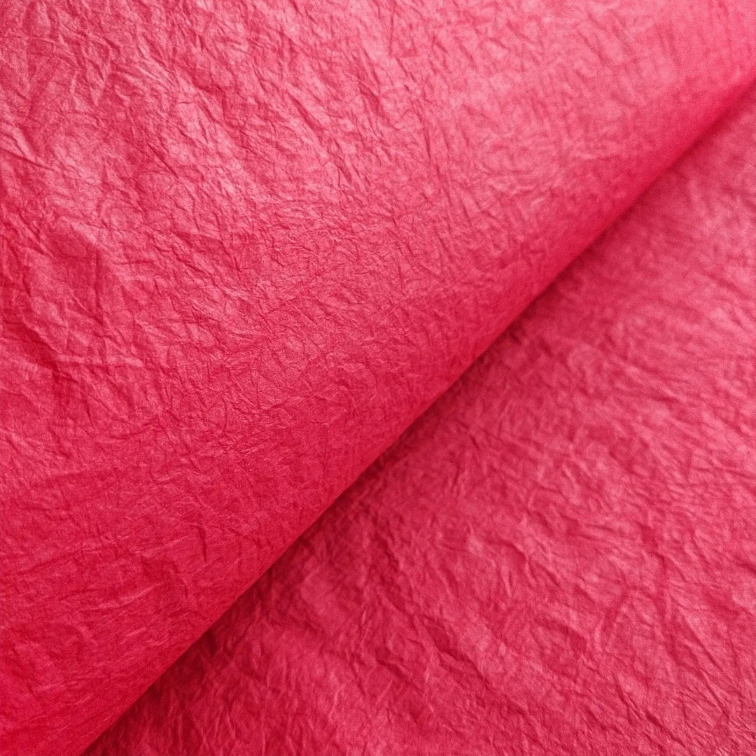 Red Momigami mulberry paper from Kozo Studio featuring a crumpled texture and flexible handmade paper ideal for crafts like bookbinding and wrapping.