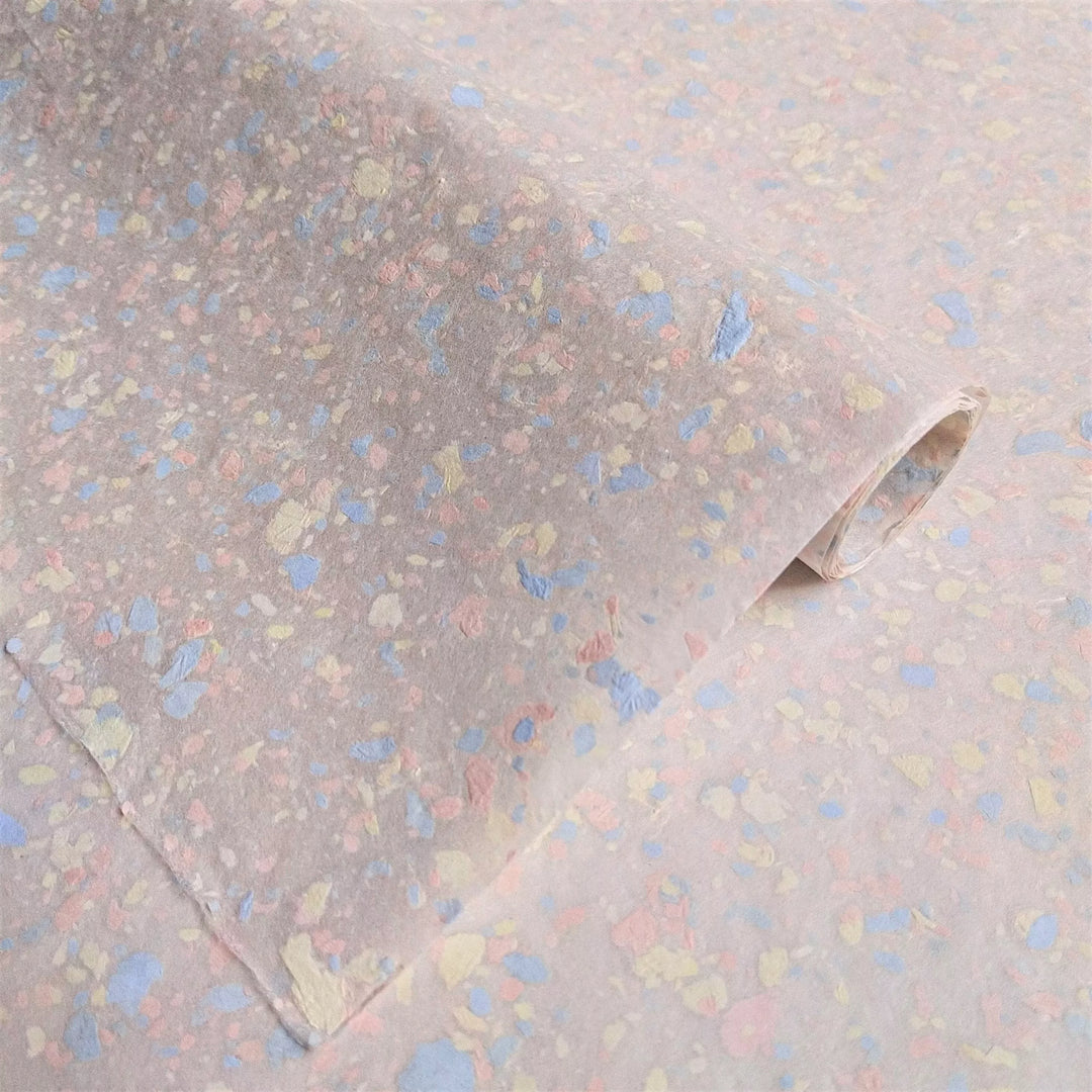 Speckled mulberry paper crafted at Kozo Studio using creamy kozo pulp and pastel bond paper accents, perfect for handmade paper art projects.