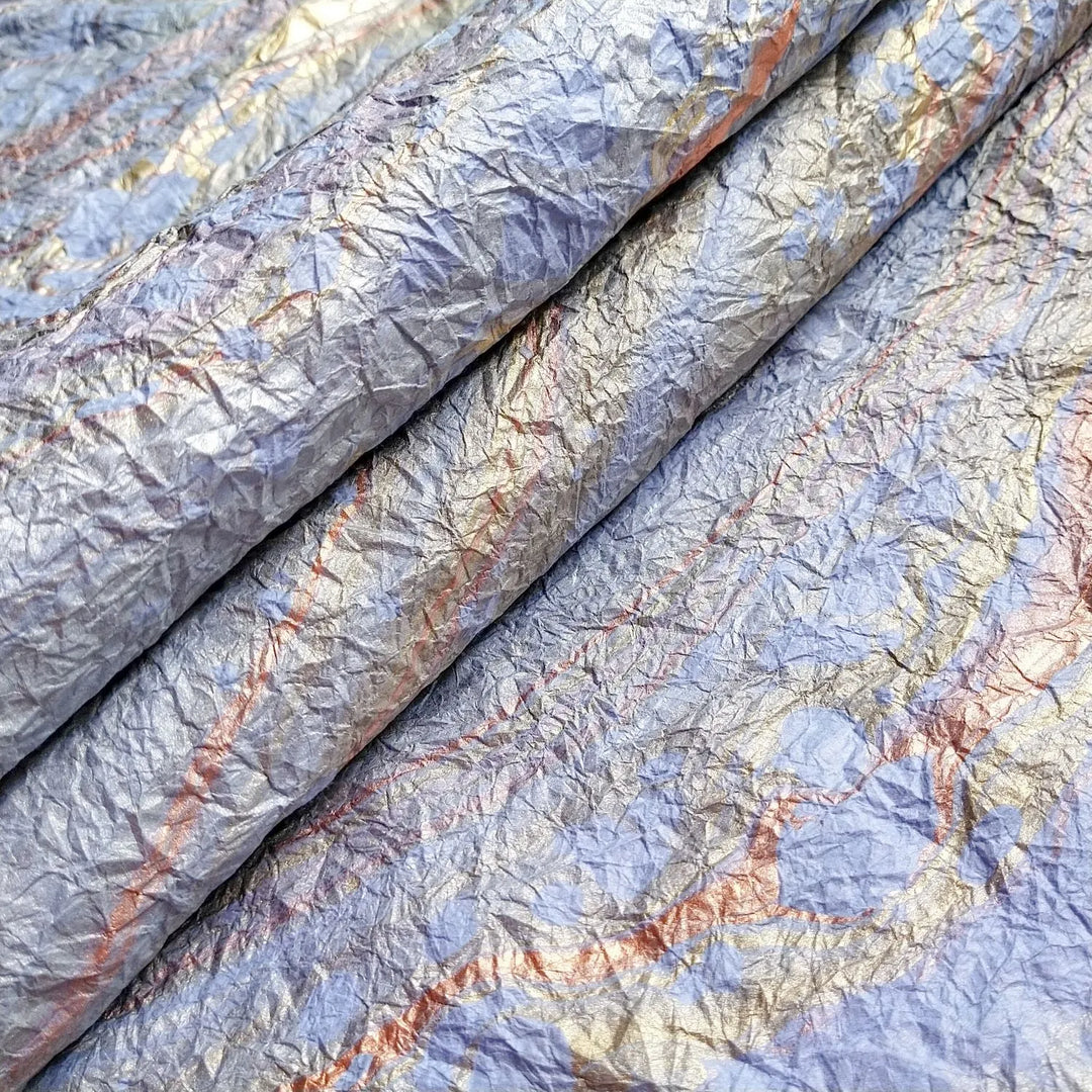 Light blue handmade mulberry paper from Kozo Studio featuring a unique marbled design with soft, crinkled texture resembling fine fabric.