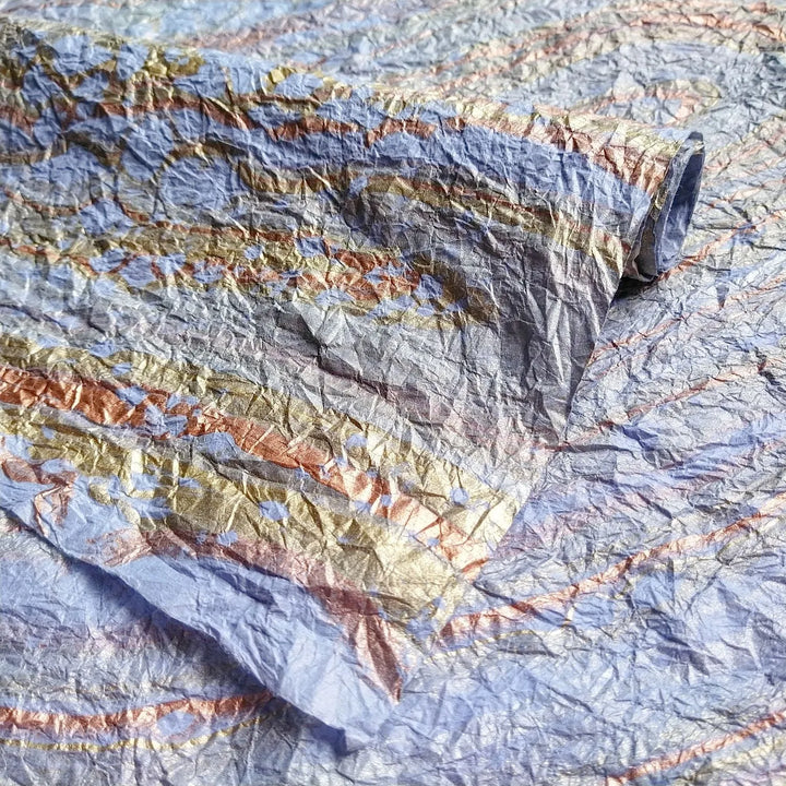 Elegant hand-marbled mulberry paper in light blue from Kozo Studio, crafted with traditional techniques for a delicate, fabric-like texture.
