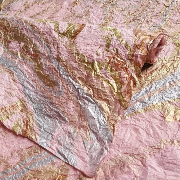 Close-up of Milano Kozo Paper Design 15, a delicate pink mulberry paper from Kozo Studio, hand-marbled with swirling oil patterns for fine art and decorative use.