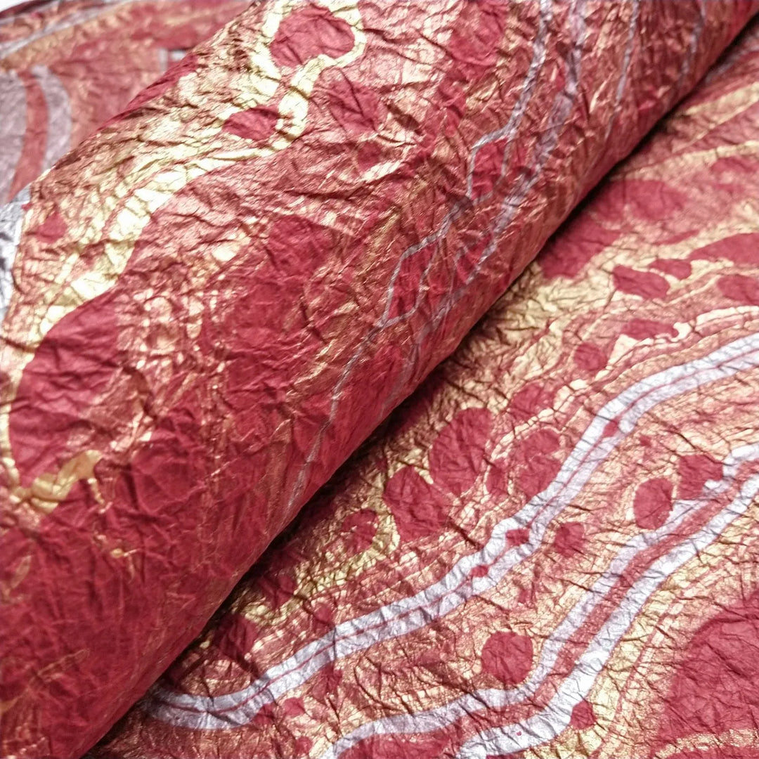 Close-up of marbled mulberry paper in red tones, individually handmade at Kozo Studio with traditional floating techniques for distinctive results.