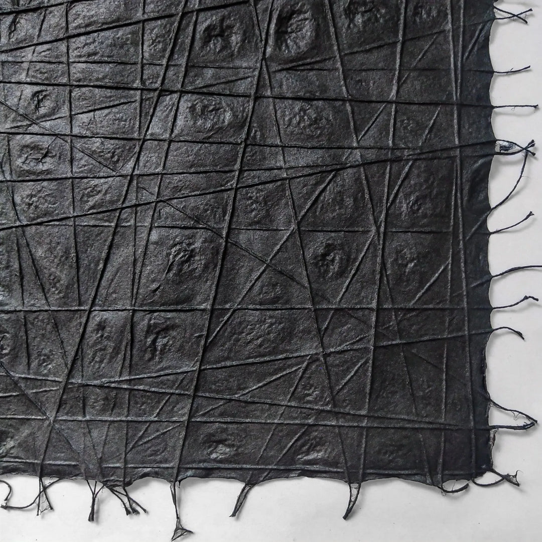 Intricately woven handmade paper from Kozo Studio, created from high-quality mulberry fibers and cotton threads laid in organic, interlaced patterns on a black background.