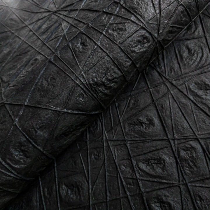 Close-up of the Handmade Interlace Kozo Paper in black from Kozo Studio, featuring a leathery, diamond-patterned texture on mulberry paper with raised intersecting lines for a rugged and tactile appearance.