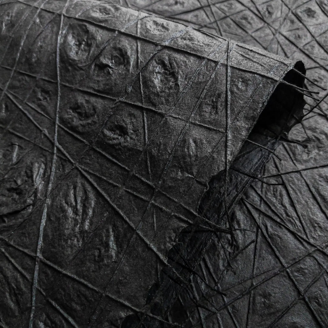 Detailed view of black mulberry paper handcrafted by Kozo Studio, featuring unique threadwork and subtle water dimpling that enhances its handmade texture and visual depth.