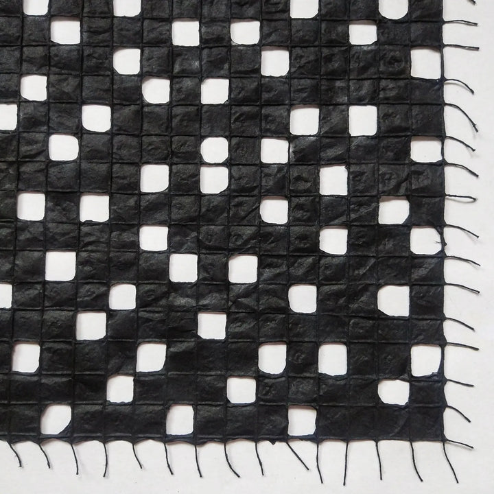 Detailed view of Kozo Studio's handmade paper made from kozo pulp, featuring a subtle and elegant cotton thread pattern.