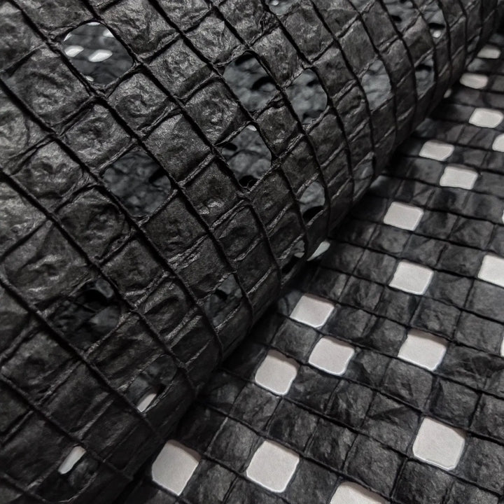 Sheet of black handmade mulberry paper from Kozo Studio, designed with meticulous cotton threading for a refined checkered effect.