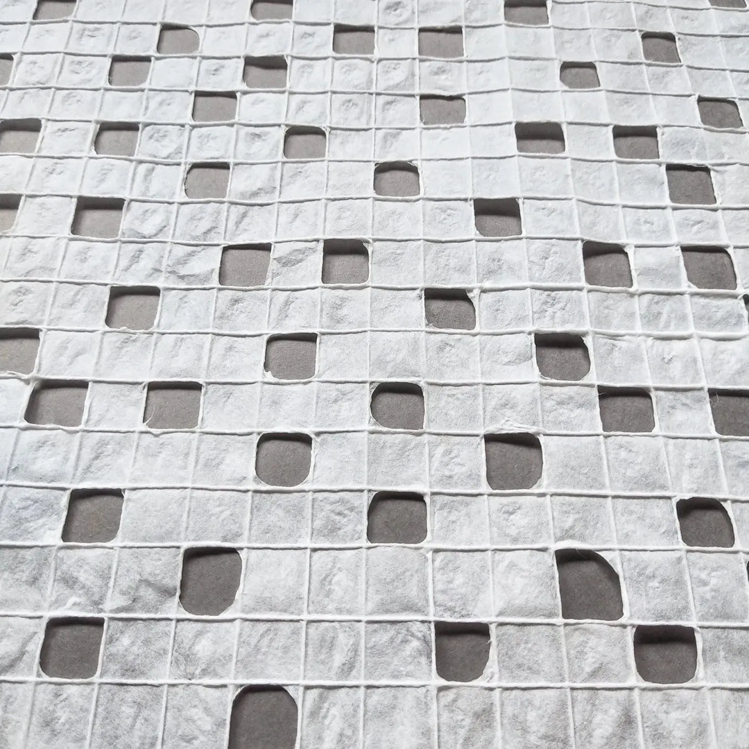 Close-up of handmade mulberry paper from Kozo Studio with a unique grid texture created by skilled artisans using traditional techniques.