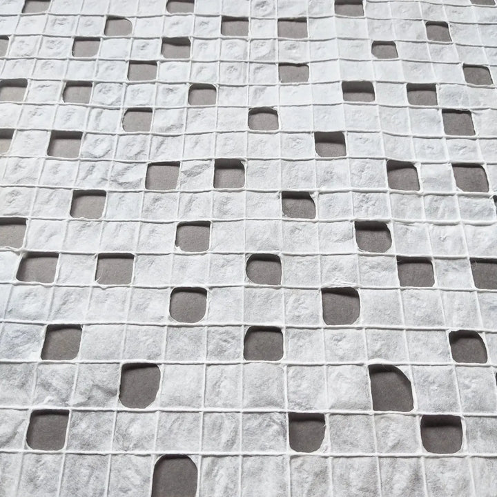 Close-up of handmade mulberry paper from Kozo Studio with a unique grid texture created by skilled artisans using traditional techniques.