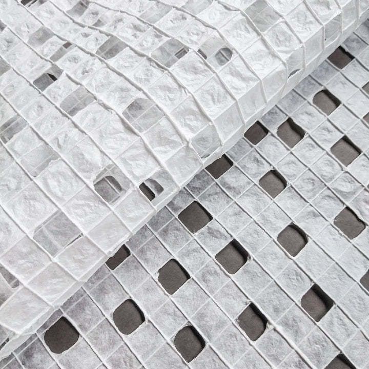 Artisan-crafted white handmade paper made from mulberry fibers at Kozo Studio, showcasing fine cotton threads woven into a checkered design.