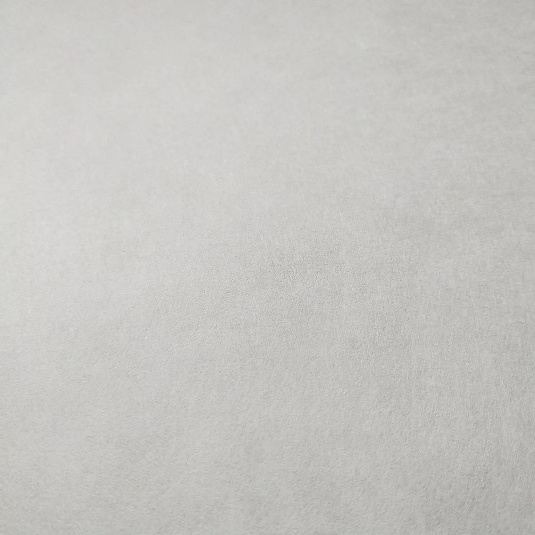 A close-up of White Kozo Paper from Kozo Studio, with its smooth, plain white surface, showcasing the delicate texture of mulberry paper.