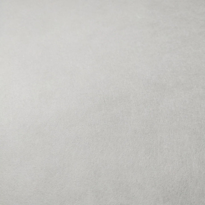 A close-up of White Kozo Paper from Kozo Studio, with its smooth, plain white surface, showcasing the delicate texture of mulberry paper.