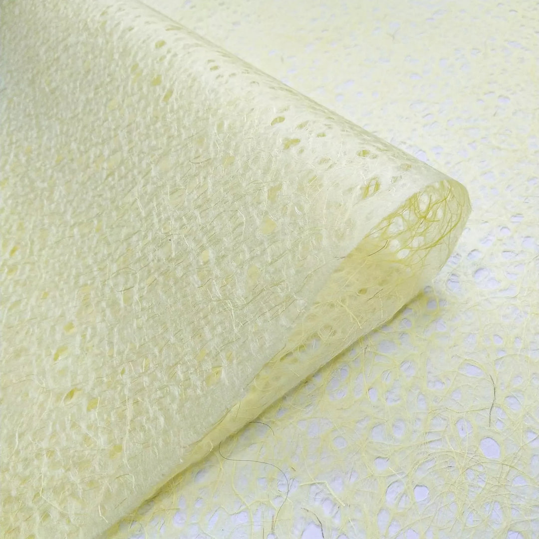 Curved sheet of yellow Kozo Studio mulberry paper, emphasizing the natural fibers and lightweight texture of premium handmade lace paper.