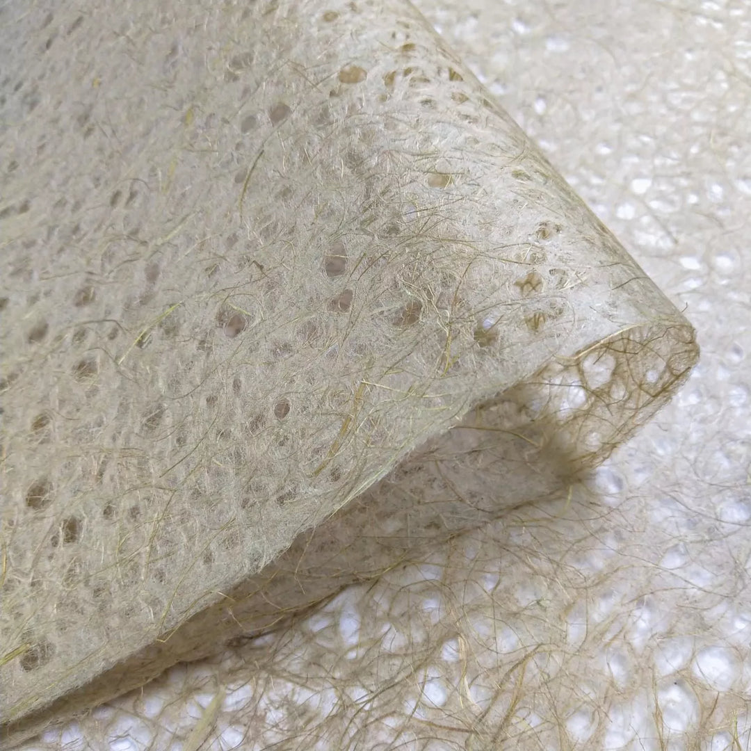Kozo Studio mulberry paper close-up showing handmade Asarakusui Lace Paper with fine, web-like patterns and translucent earthy beige texture.