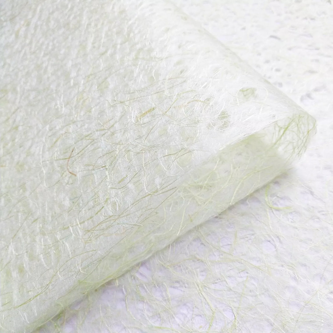 Organic close-up of Kozo Studio Asarakusui lace paper, made from mulberry fibers, with a soft handmade texture in light green and beige.
