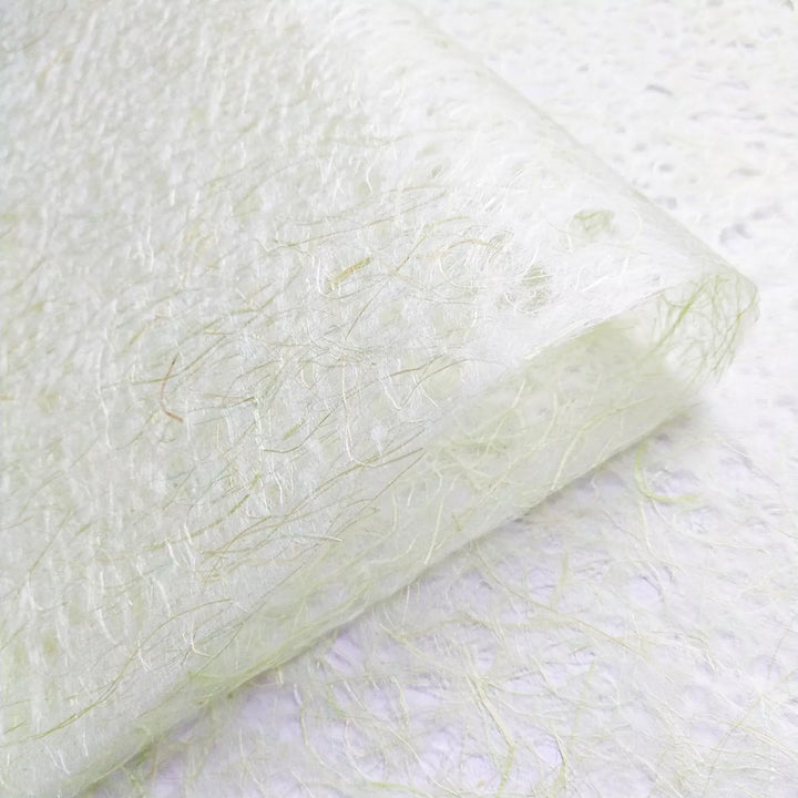 Organic close-up of Kozo Studio Asarakusui lace paper, made from mulberry fibers, with a soft handmade texture in light green and beige.