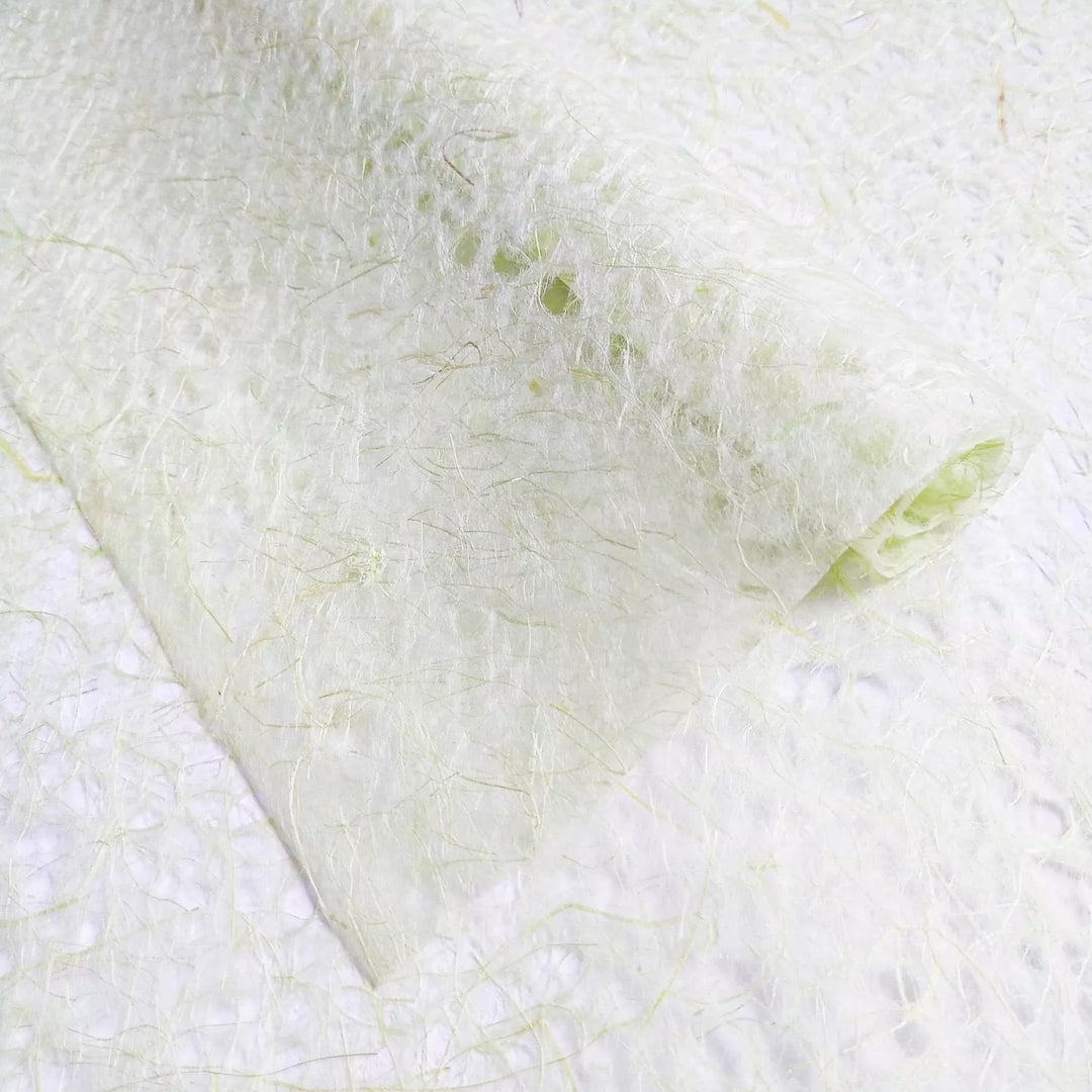 Detailed image of Kozo Studio mulberry paper with a lace-like design, highlighting the handmade paper's light green and beige fibrous texture.