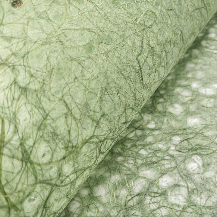 Close-up of Kozo Studio handmade paper showcasing Asarakusui Lace Paper in Moss with intricate green fibers and natural mulberry texture.