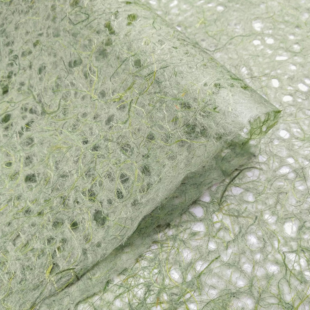 Artistic texture of handmade paper from Kozo Studio featuring moss-toned Asarakusui Lace made from traditional mulberry fibers.