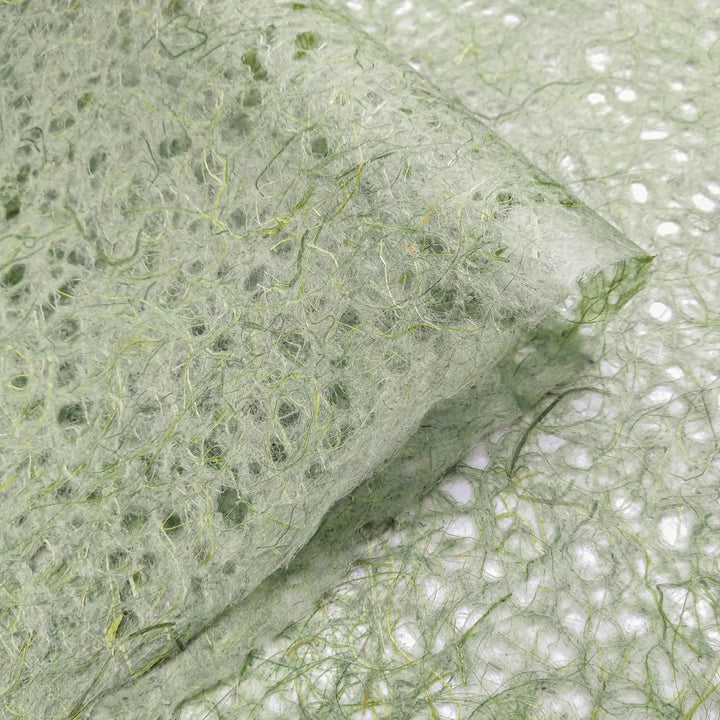 Artistic texture of handmade paper from Kozo Studio featuring moss-toned Asarakusui Lace made from traditional mulberry fibers.
