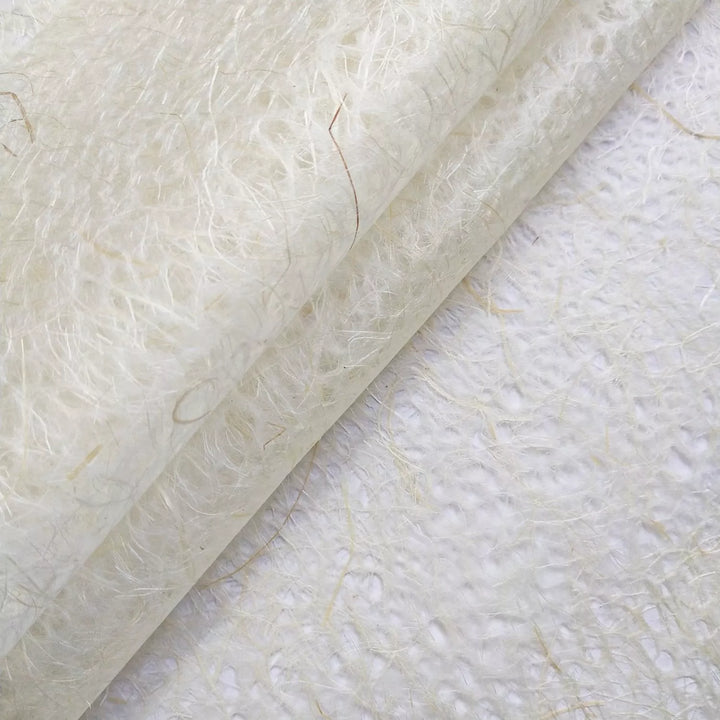 Textured surface of handmade mulberry paper from Kozo Studio, showing translucent layers and organic patterns created by water-dropping technique.