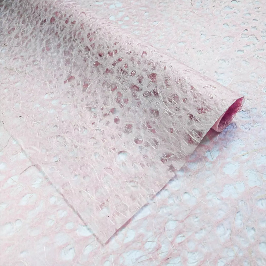 Textured surface of handmade mulberry paper by Kozo Studio, featuring pink Asarakusui Lace with fibrous translucent design and brown natural threads.