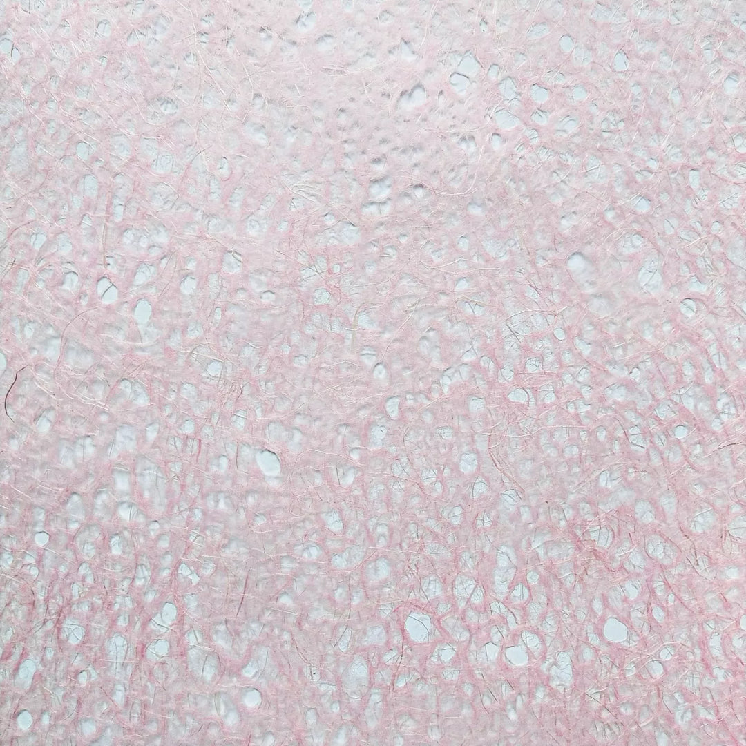 Handmade mulberry paper by Kozo Studio featuring Asarakusui Lace design in pink with visible fibers and delicate brown thread patterns.