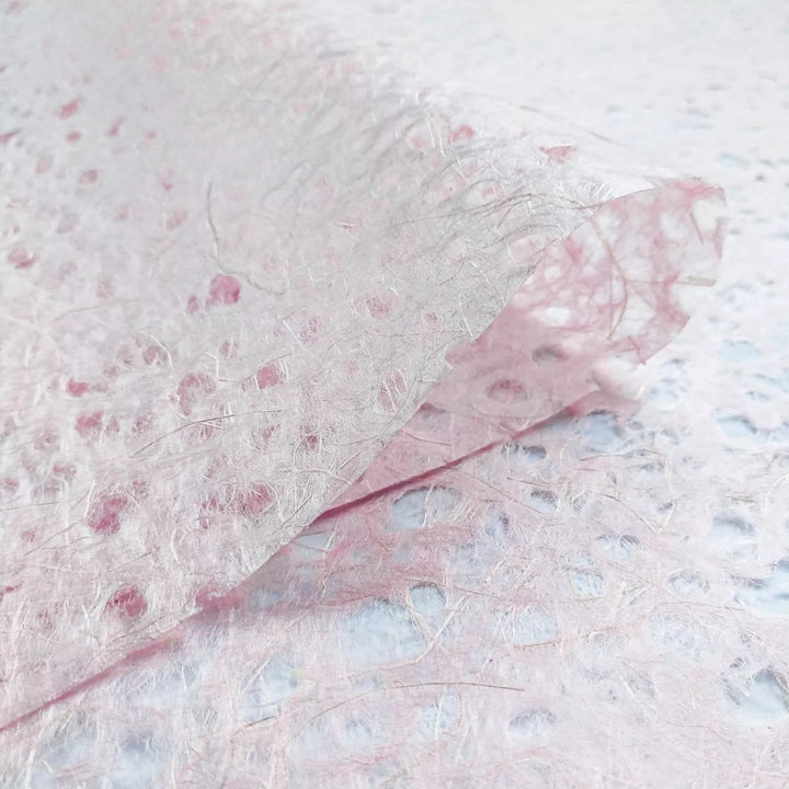 Kozo Studio mulberry paper close-up showing handmade Asarakusui Lace texture with pink and brown fiber threads for an organic aesthetic.