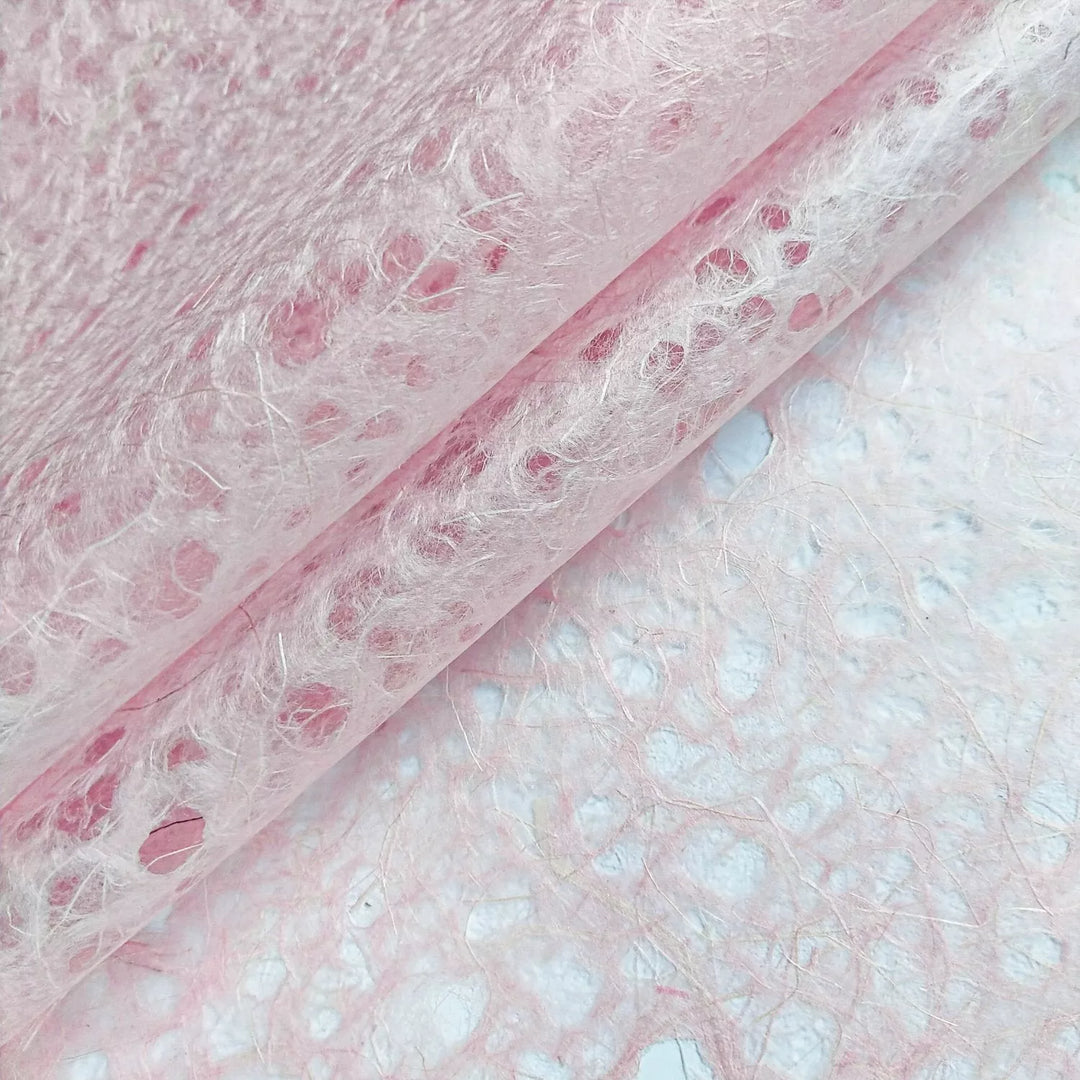 Detail view of Kozo Studio handmade paper highlighting pink Asarakusui Lace made from mulberry paper with a soft natural finish and textured fibers.