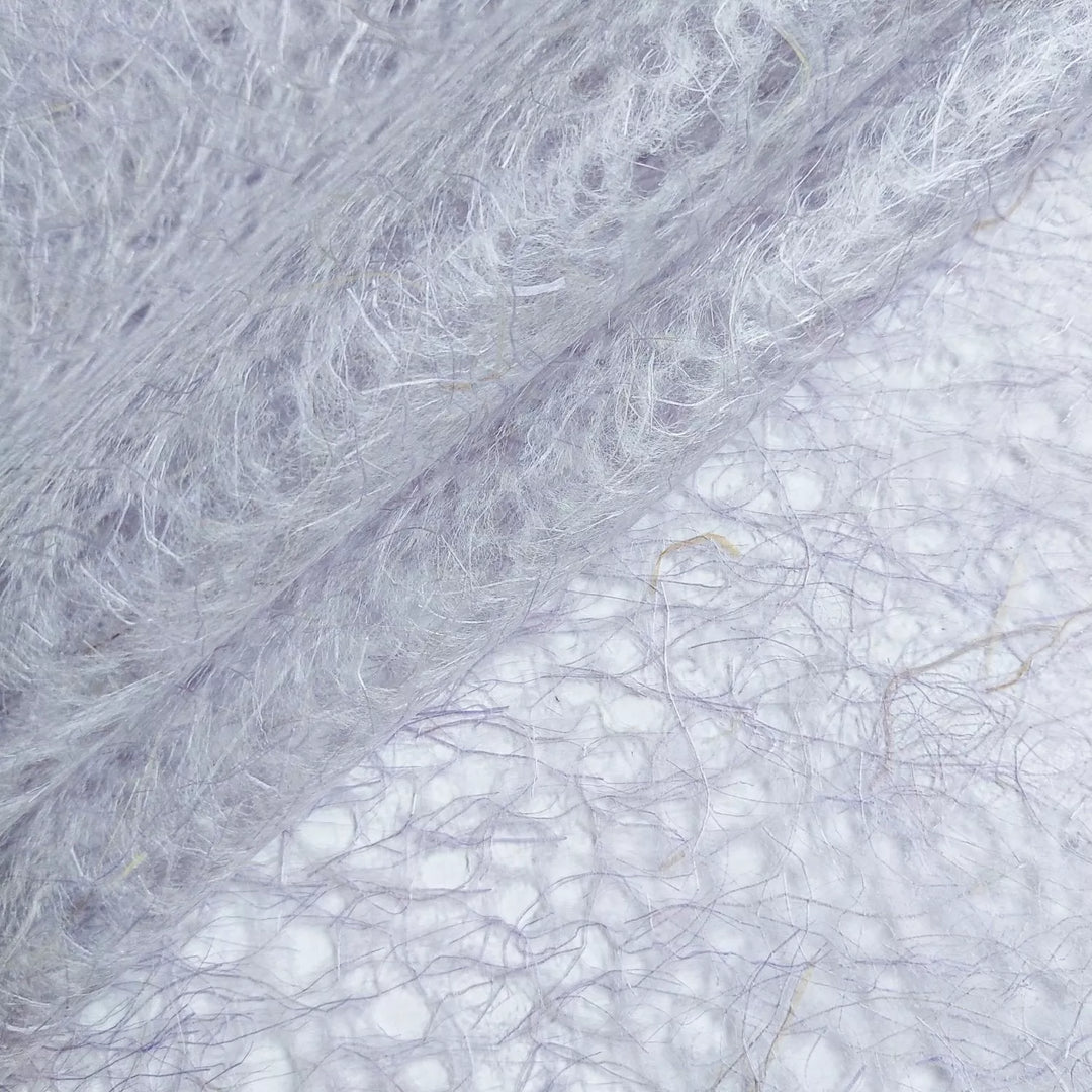 Intricate purple mulberry paper crafted by Kozo Studio, featuring a lace-like pattern and organic handmade paper texture.