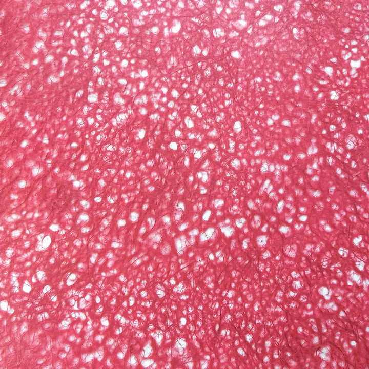 Detailed view of handmade Asarakusui Lace Paper in red from Kozo Studio, showcasing the fibrous structure and delicate layering of mulberry paper.
