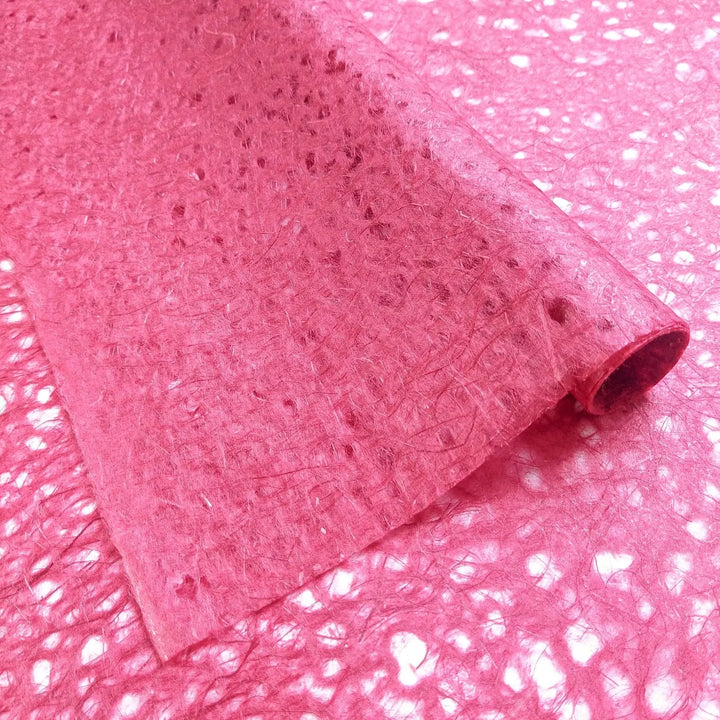 Artistic close-up of Kozo Studio's red lace-style mulberry paper, capturing the handmade fibrous web and tonal variations that add visual complexity.