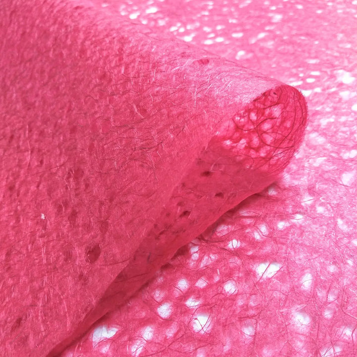 Red Asarakusui handmade paper by Kozo Studio, displaying its translucent quality and detailed mulberry fiber composition in an artistic close-up.